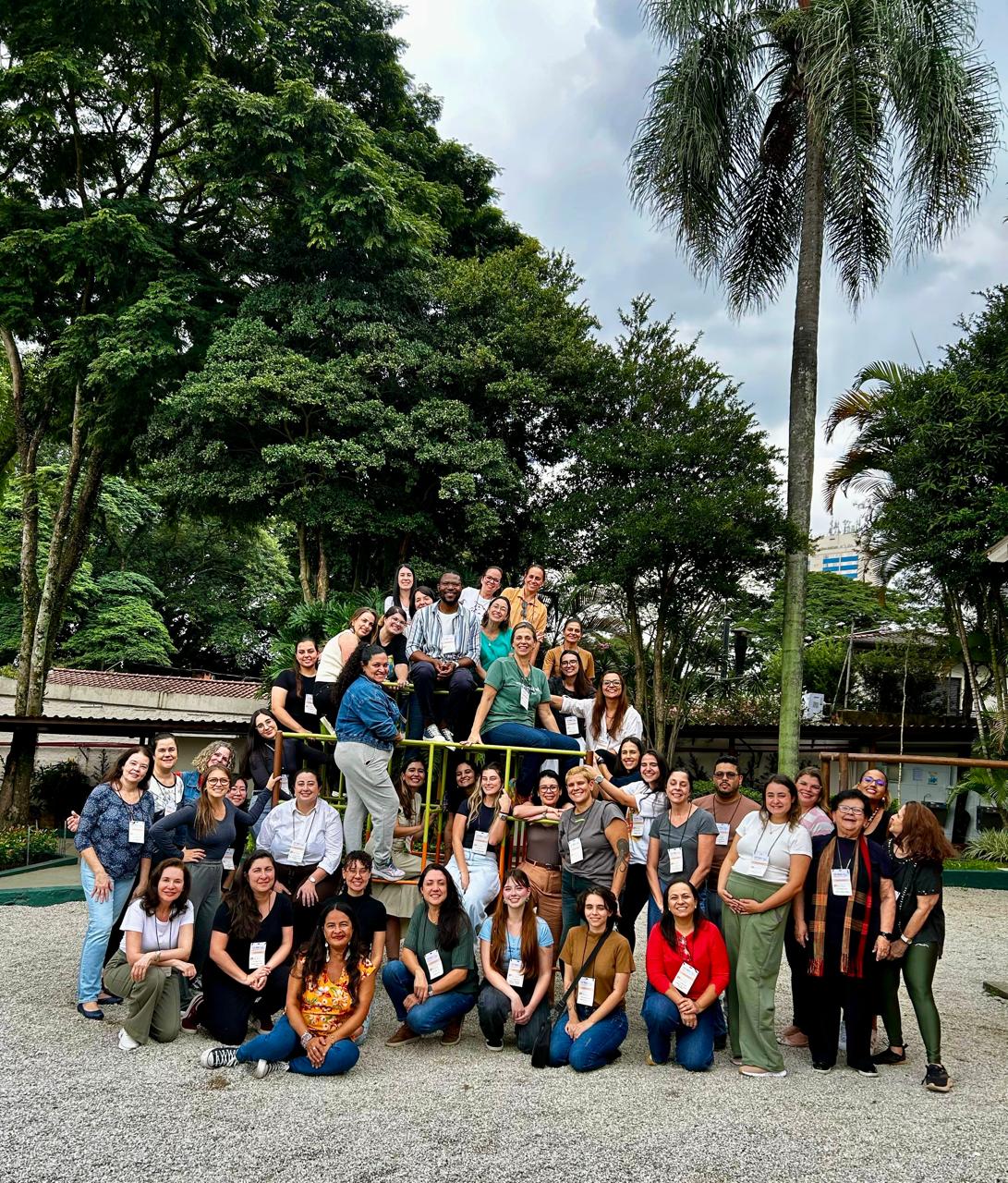 Grupo de educadores reunidos ao ar livre em formação anterior
