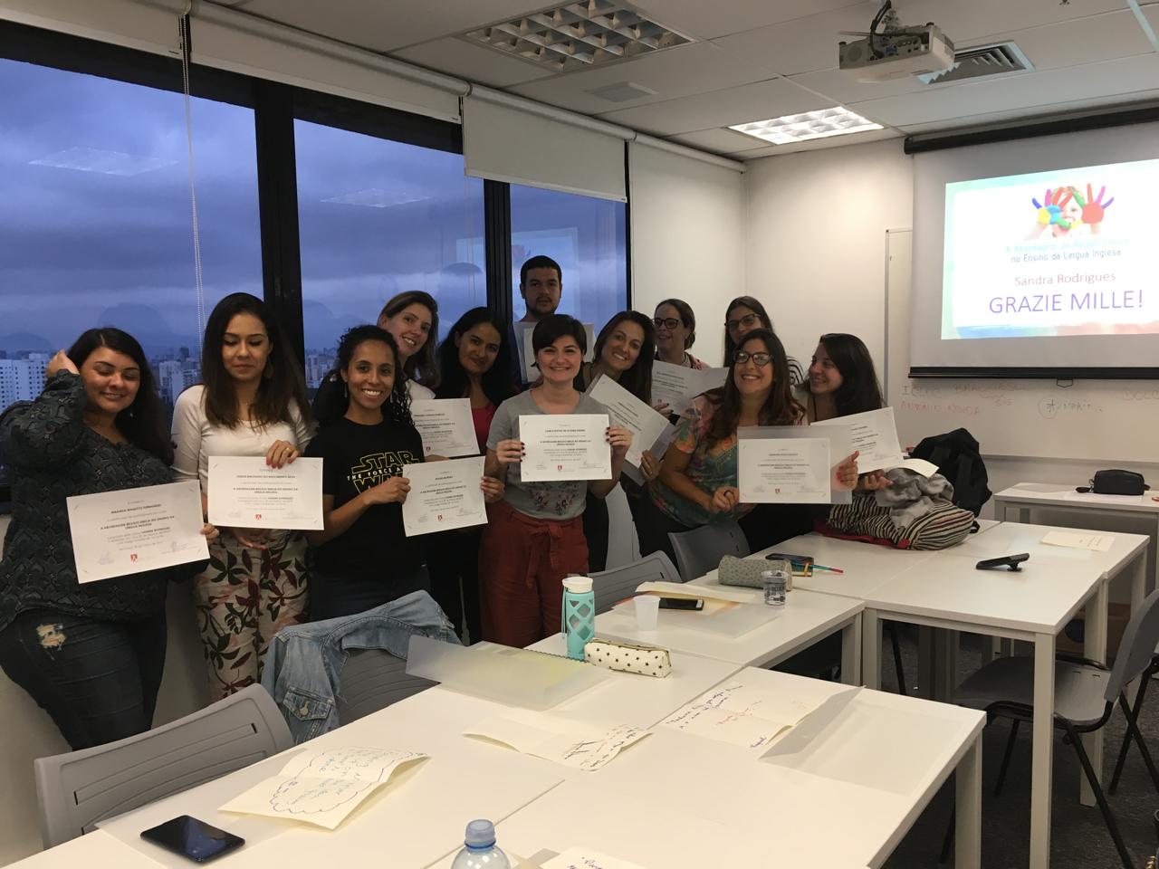 Turma de educadores com certificados ao final de um curso